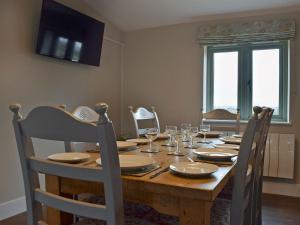 a wooden table with chairs and a dining room at Wagtail Cottage in Foxton