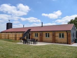 a wooden cabin with a picnic table in front of it at Wagtail Cottage in Foxton