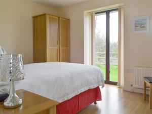 - une chambre avec un lit et une lampe sur une table dans l'établissement Bramley Cottage, à Brean