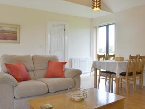 a living room with a couch and a table at Bramley Cottage in Brean