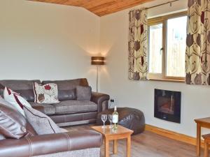 a living room with a leather couch and a window at Hillside View in Llandrindod Wells