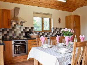 a kitchen with a dining room table with flowers on it at Hillside View in Llandrindod Wells