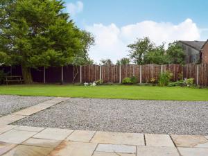 a garden with a wooden fence and a lawn at West Boundary Farm Cottage 2 in Pilling