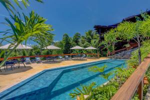 una piscina con sedie, tavoli e ombrelloni di Chocolate Hotel a Itacaré