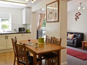 cocina y comedor con mesa de madera y sillas en Mole en Swimbridge