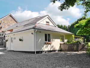 een wit huis met een garage bij Mole in Swimbridge