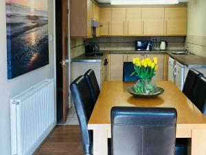 a kitchen with a table with a vase of flowers on it at Stiff Key Barn 30955 in Thursford