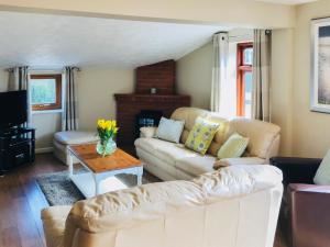 ein Wohnzimmer mit einem Sofa und einem Tisch in der Unterkunft Stiff Key Barn 30955 in Thursford