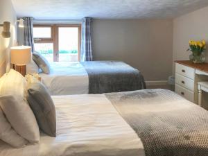 a bedroom with two beds and a window at Stiff Key Barn 30955 in Thursford