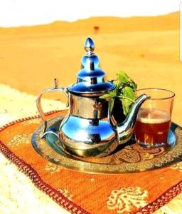 una tetera y una taza de té sobre una mesa en BerberNightCamp, en Adrouine