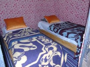 dos camas sentadas una al lado de la otra en una habitación en BerberNightCamp, en Adrouine