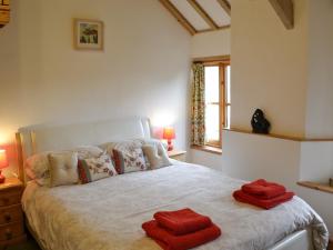 a bedroom with a large bed with red towels on it at Sparrows in Morvah