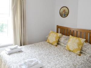 a bedroom with a bed with towels on it at Youngers Cottage in Warkworth