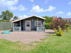 Bempton的住宿－Rockville Cottage - 24376，花园中一个小蓝色房子,有院子