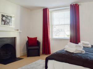 1 dormitorio con cama, ventana y silla en Warner Lea, en Bowness-on-Windermere
