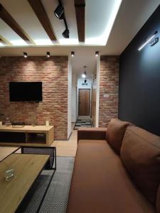 ein Wohnzimmer mit Sofa und Ziegelwand in der Unterkunft Blackwood Hill in Belgrad