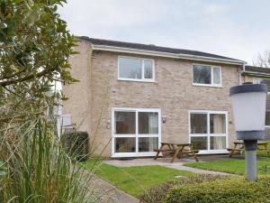 a brick house with a picnic table in front of it at Newquay Holiday Villa in Saint Columb Major