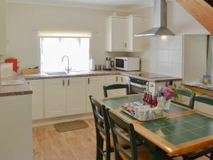 a kitchen with a table with chairs and a counter top at The Wherry Arch in Neatishead