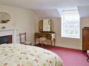 a bedroom with a bed and a desk and a mirror at The Mews in Insch