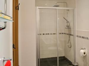 a shower with a glass door in a bathroom at Yr Ysgubor in Sarnau