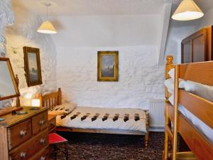 LlangwnadlにあるPorth Cormon Farmhouseのベッドルーム1室(ツインベッド2台、ドレッサー付)