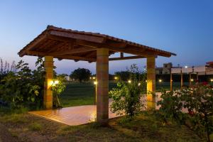drewniana pergola w ogrodzie w nocy w obiekcie Agriturismo Il Gelsomino Ritrovato w mieście Milazzo
