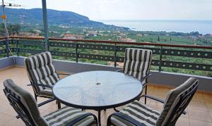 a table and chairs on a balcony with a view at Βίλα Ηρώ in Riglia