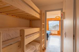 a room with two bunk beds and a hallway at Charming studio at the foot of the ice rink in Le Grand-Bornand