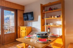 a dining room with a table and a television at Charming studio at the foot of the ice rink in Le Grand-Bornand
