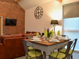 a living room with a table with chairs and a couch at Bluebell Barn in Dunnington