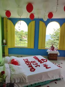 a bedroom with a bed with red balloons on it at Tayrona Colors Hostel in Taganga
