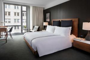 a bedroom with a large white bed and a desk at Smyth Tribeca in New York