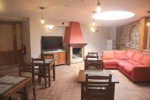 a living room with a red couch and a fireplace at Hostal Rural 18 de Abril in Olite