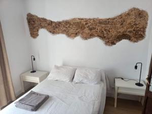 a bedroom with a bed with a branch on the wall at Piso centro de Cádiz in Cádiz