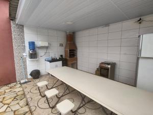 uma cozinha com um balcão e cadeiras num quarto em Chalé Arizona em São Roque