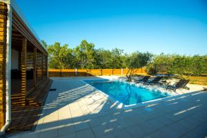 - une piscine avec 2 chaises sur la terrasse dans l'établissement MY DALMATIA - Holiday home Relax with private pool, à Sveti Filip i Jakov