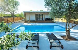 - une piscine avec 2 chaises et une maison dans l'établissement MY DALMATIA - Holiday home Relax with private pool, à Sveti Filip i Jakov