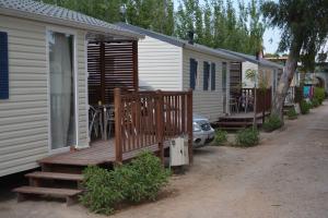a house with a porch and a deck with a table at Camping Valencia el Saler in El Saler