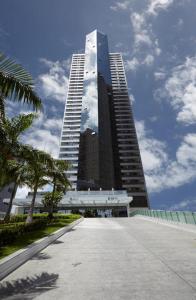 un edificio alto di fronte a un grande edificio di Flat Beira Mar Boa Viagem- Beach Class Internacional a Recife