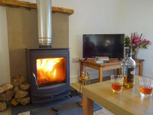 a fireplace in a living room with a table and a table at Charlies Cottage in Muasdale