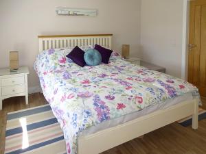 um quarto com uma cama com colcha floral em Charlies Cottage em Muasdale