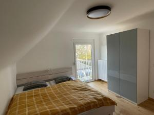 um quarto com uma cama e uma grande janela em Ferienhaus Molitor em Klagenfurt