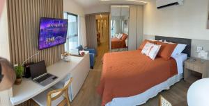 1 dormitorio con 1 cama y escritorio con ordenador portátil en Flat Beira Mar Boa Viagem- Beach Class Internacional, en Recife