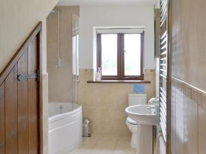 bagno con vasca, lavabo e servizi igienici di Cider Barn a Poundstock