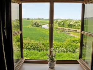 una ventana con una maceta sentada en un alféizar en The Barn en Gringley on the Hill