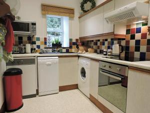 a kitchen with a washer and dryer in it at Moorlands Cottage in Levisham