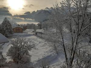 a snow covered road with trees and a building at Appartamento Elisa in Taibon