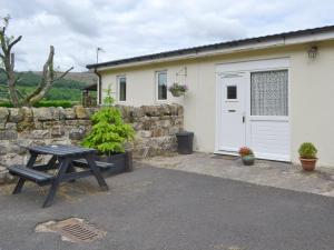 a picnic table in front of a building with a garage at Stable Cottage - Ukc645 in Byrness