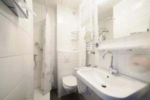 a white bathroom with a sink and a toilet at Hotel Dordrecht in Dordrecht +30 photos