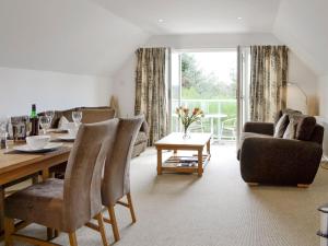 a living room with a table and chairs and a couch at 32 Queens Court in Inchmarlo